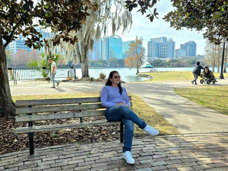 Mulher sentada em um banco no Eola Park em Orlando